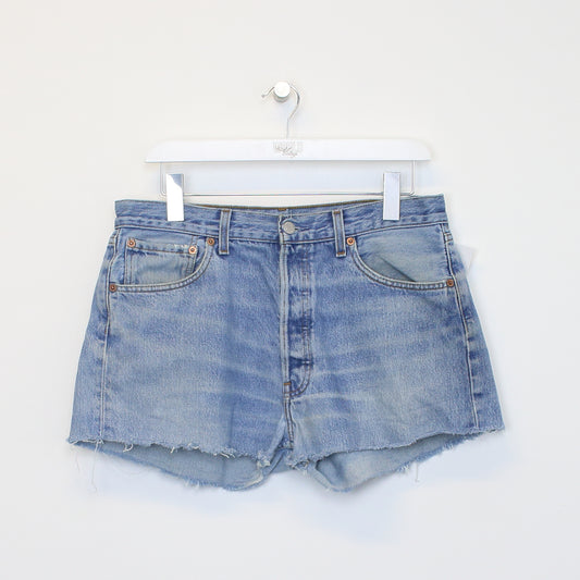 Vintage Women's Levi's denim cut off shorts in blue. Best fits W31