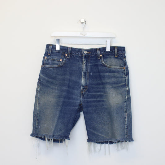 Vintage Levi's denim cut off shorts in blue. Best fits W34