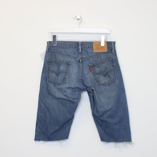 Vintage Levi's denim cut off shorts in blue. Best fits W30