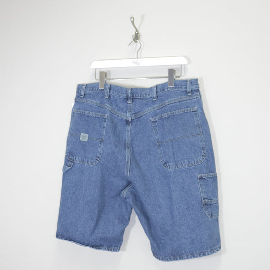 Vintage Wrangler denim cargo shorts in blue. Best fits W30